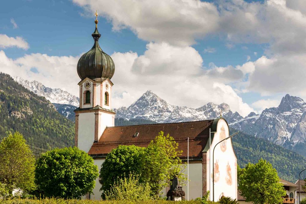 Small white church with mountains in Germany